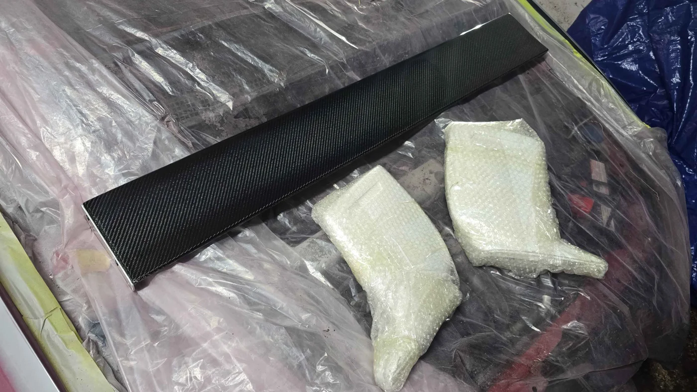 Carbon fibre rear wing with wrapped mounting components